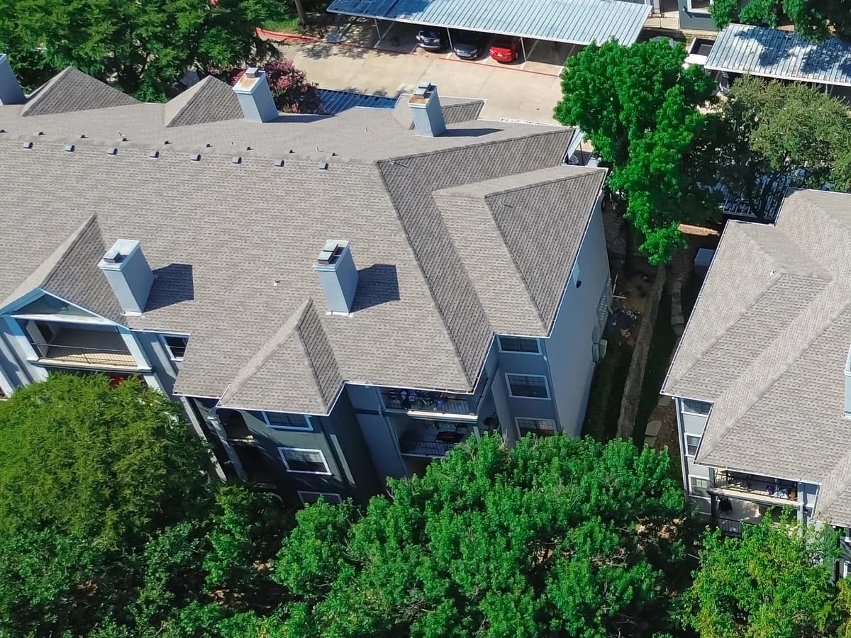 Aerial view of shingle roofs on an apartment community