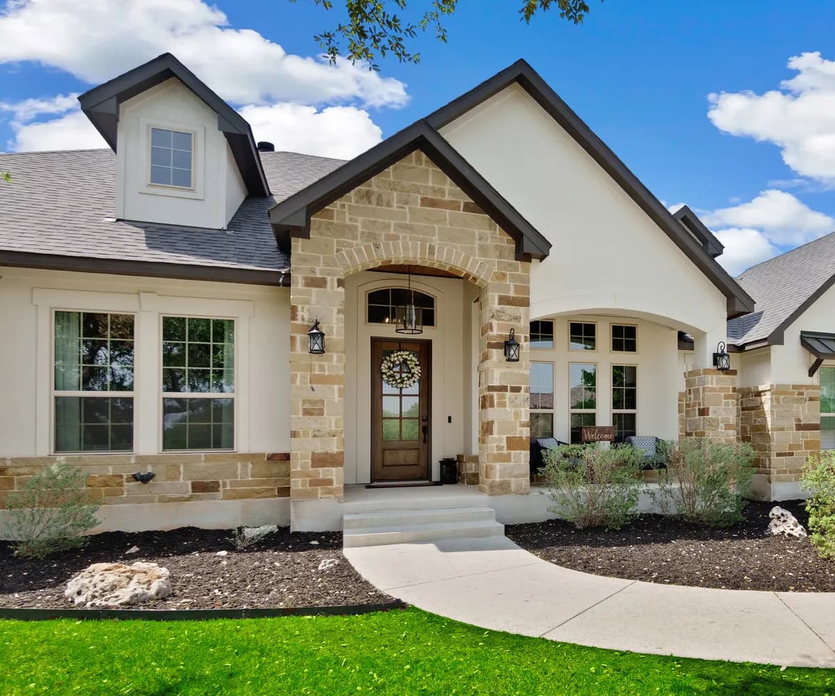 New stucco and stone home with an architectural shingle roof