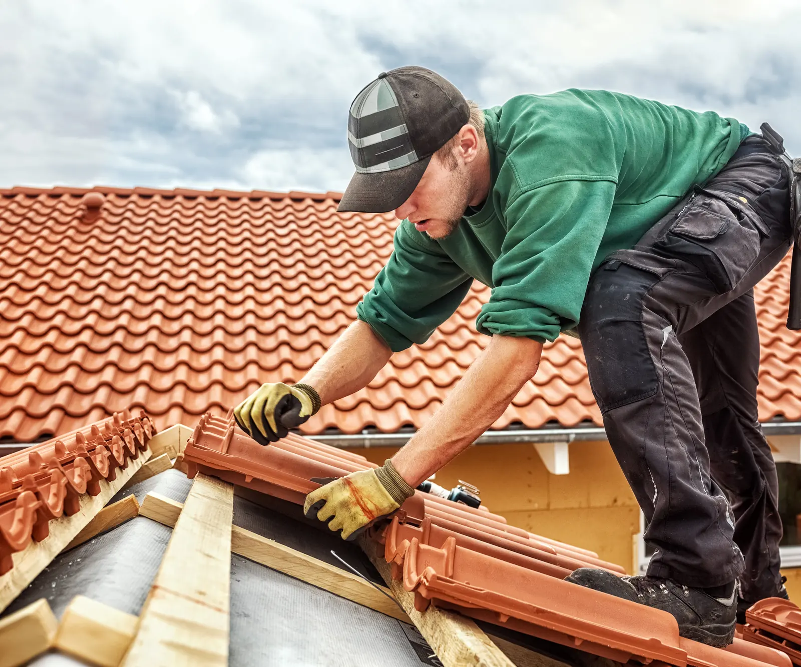 Roofer installing clay roof tiles