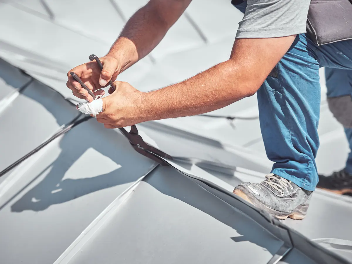 Roofer working on a standing seam metal roof