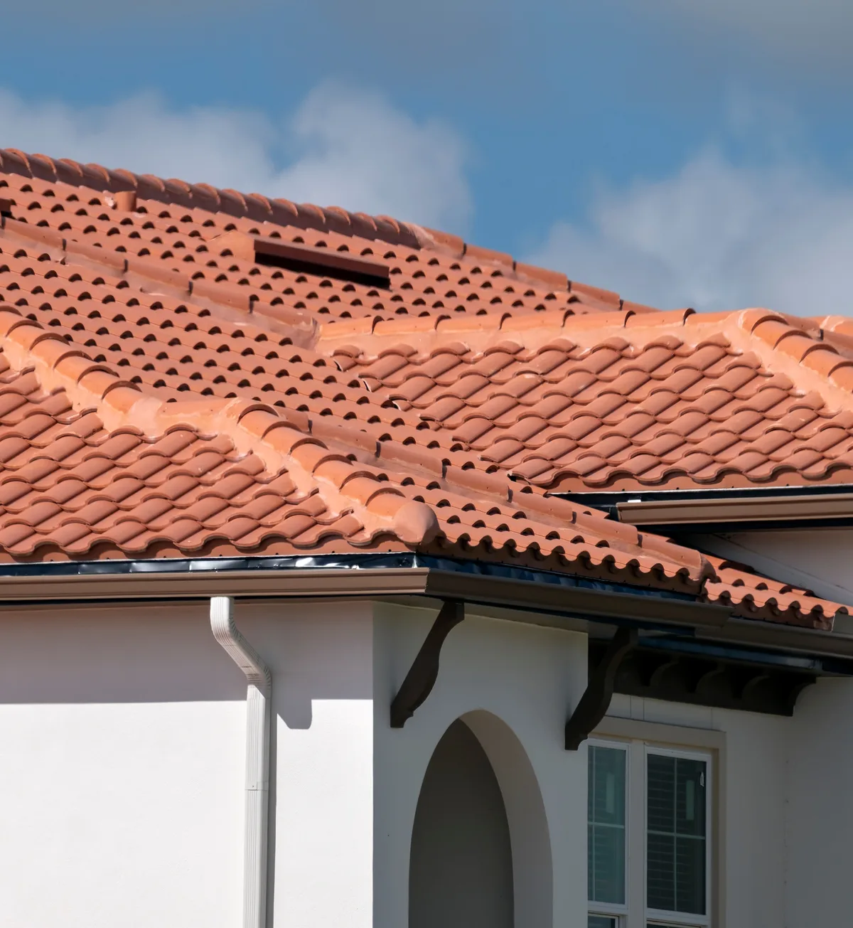 Tile roof over a white stucco Florida home with an arched entry