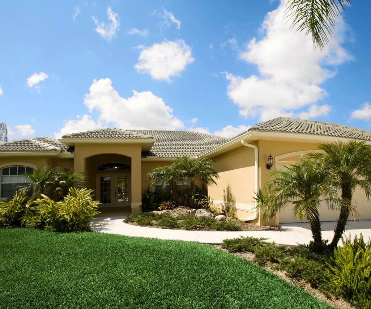 Stucco home with a tile roof and palms