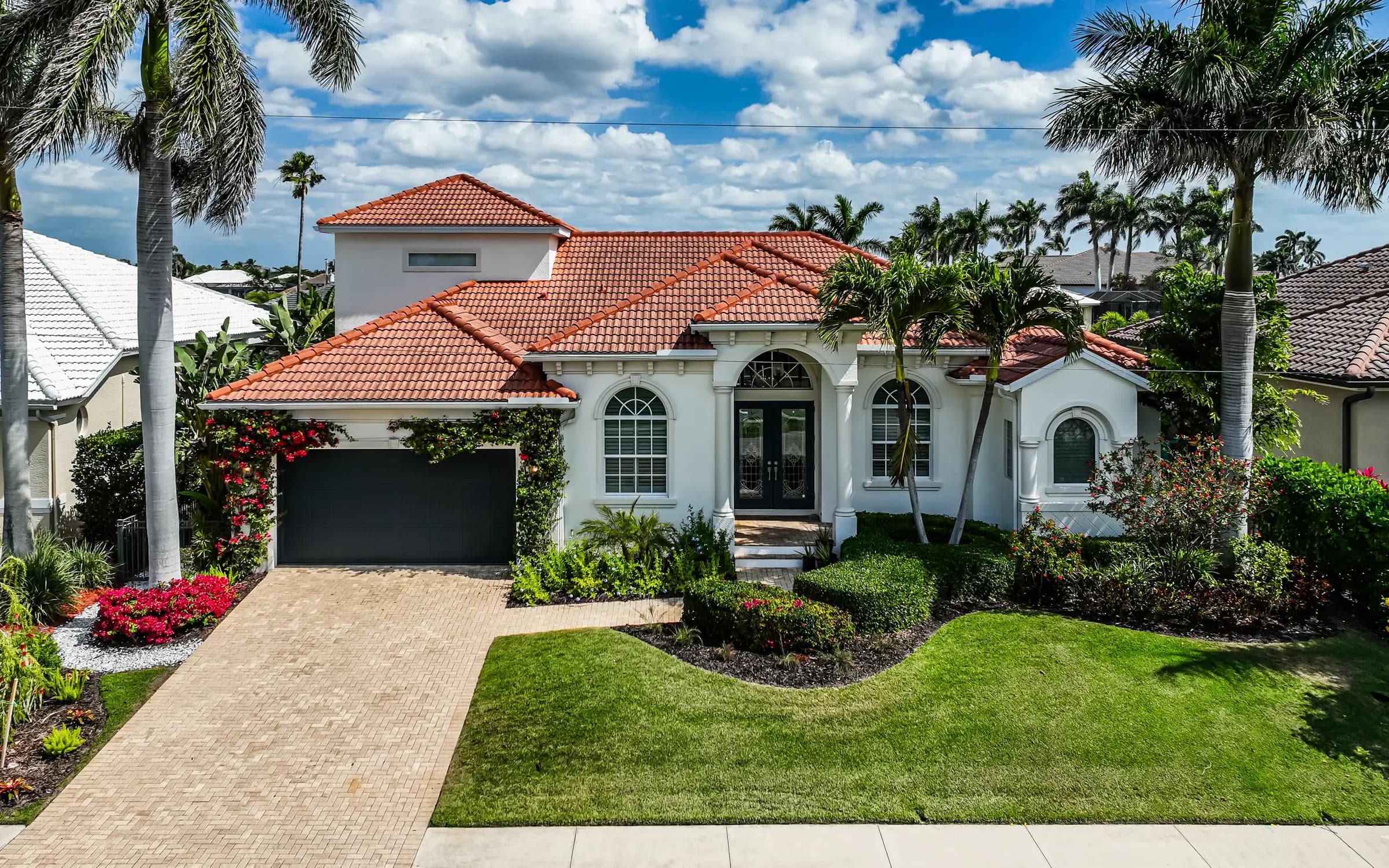 Florida home with a tile roof and palm trees