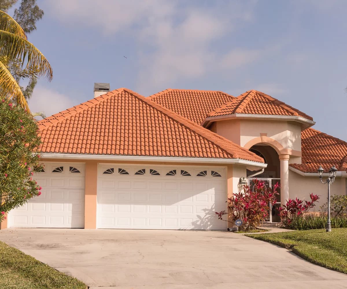 Florida ranch home with a terracotta tile roof and a three-car garage