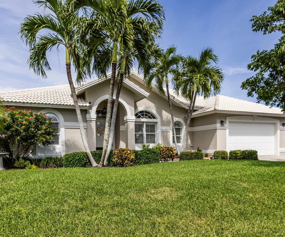 Florida home with a white tile roof and palm trees